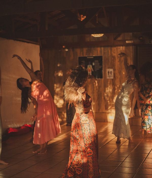 Woman performing a gentle, flowing cardio movement in a bright, sunlit room.